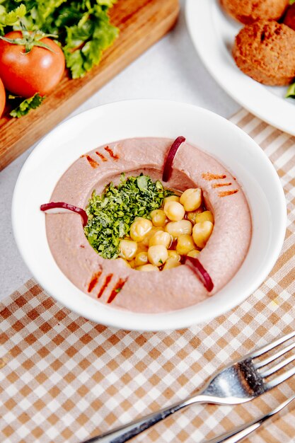 Vista lateral del hummus tradicional del Medio Oriente con garbanzos y aceite de oliva