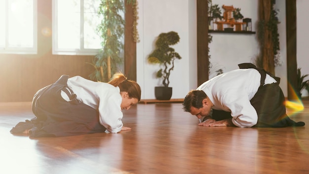 Vista lateral de los instructores de artes marciales que se saludan antes de entrenar