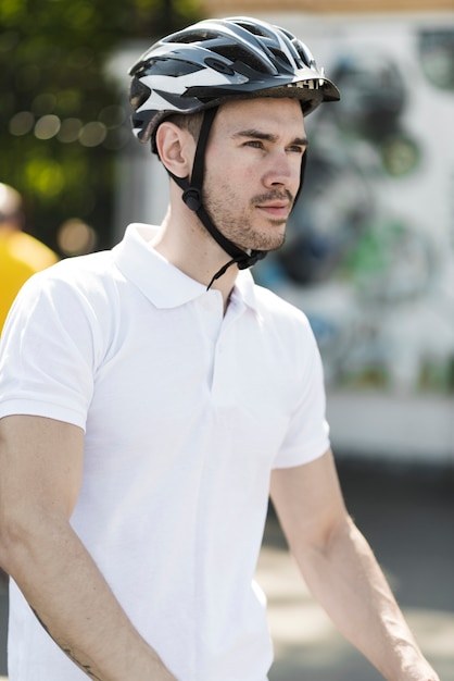 Vista lateral del joven ciclista masculino con casco protector