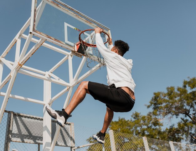 Vista lateral joven jugando baloncesto