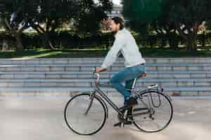 Foto gratuita vista lateral de un joven montando bicicleta en el parque