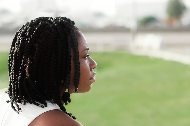 Vista lateral joven mujer nigeriana al aire libre