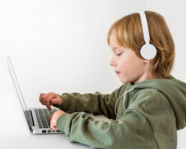 Foto gratuita vista lateral del joven con portátil con auriculares