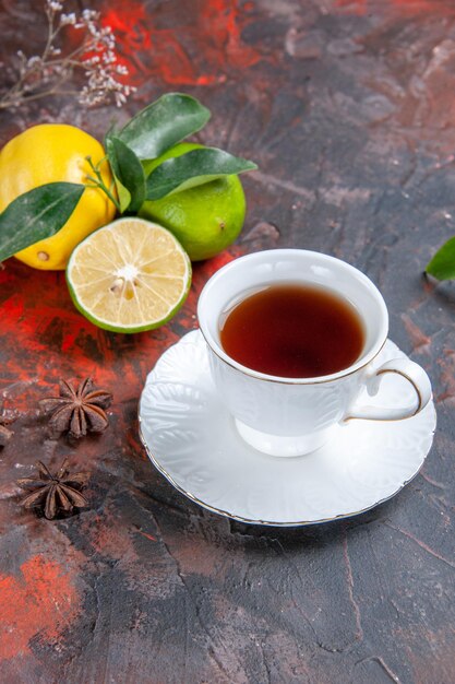 Vista lateral desde lejos una taza de té una taza de té negro limones con hojas de anís estrellado