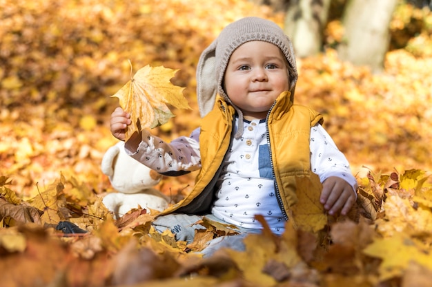 Vista lateral lindo bebé jugando con hojas