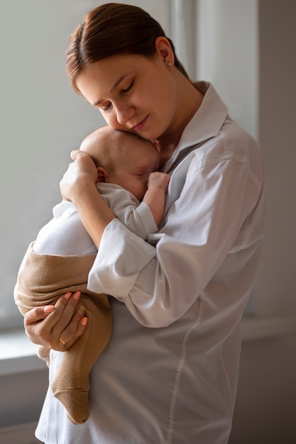 Foto gratuita vista lateral madre con bebé en casa