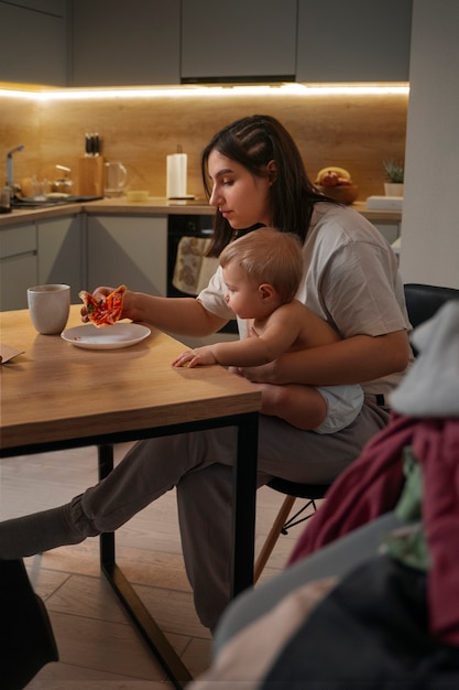 Foto gratuita vista lateral madre y bebé con comida.