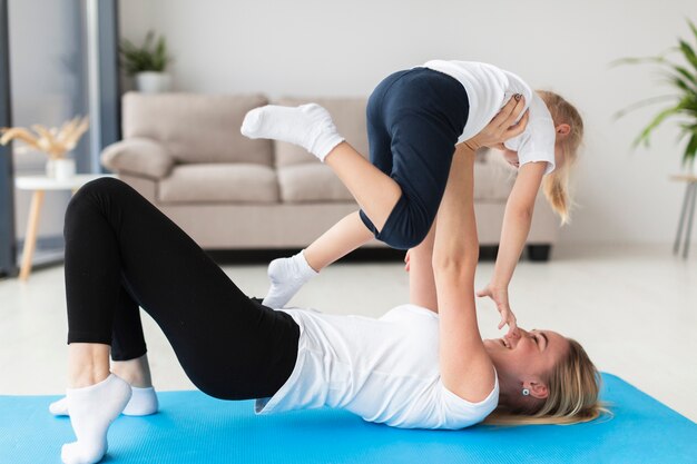 Vista lateral de la madre y el niño haciendo ejercicio en casa