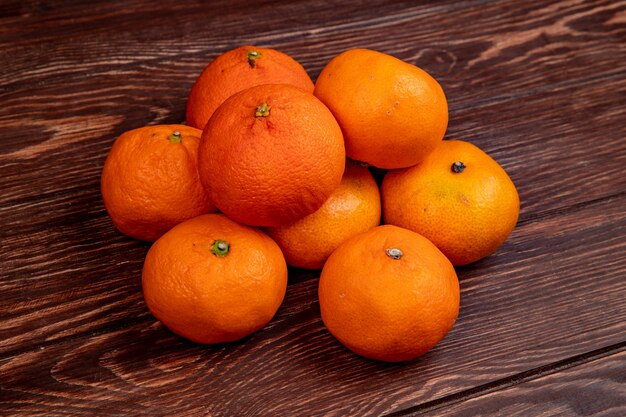 Vista lateral de mandarinas frescas maduras aisladas en madera rústica