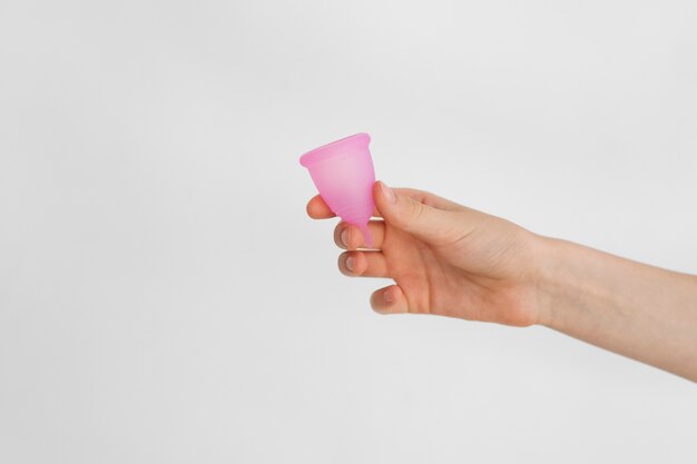 Vista lateral mano sosteniendo producto menstrual reutilizable