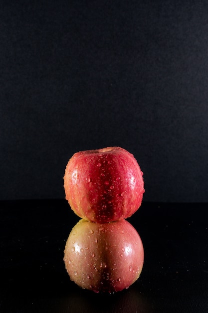 Vista lateral manzanas rojas húmedas en blac¡k