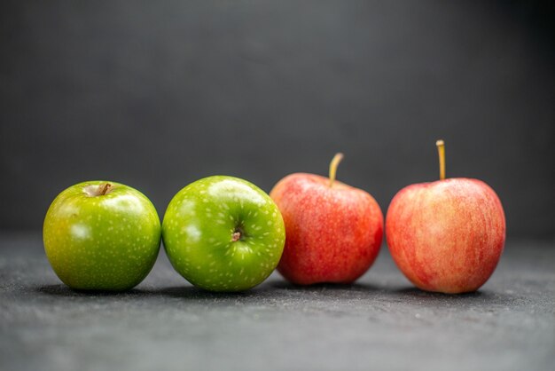 Vista lateral de manzanas rojas y verdes frescas como parte de la vida sana en la mesa oscura