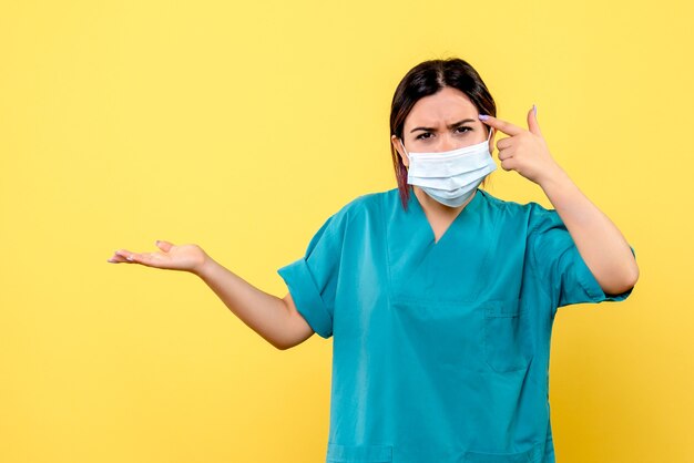 Vista lateral de un médico con máscara está hablando de pacientes con covid