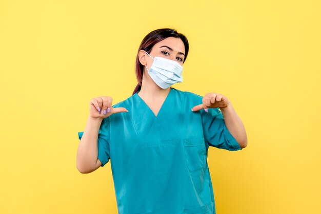 Vista lateral de un médico con máscara está orgulloso de que curó a los pacientes