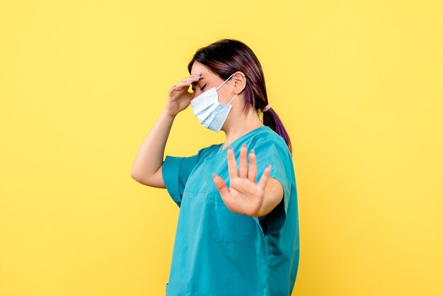 Vista lateral de un médico con máscara está pensando en pacientes con coronavirus