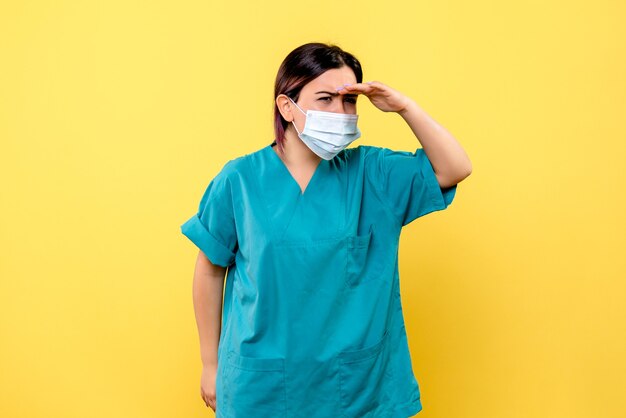 Vista lateral de un médico con máscara está pensando en los síntomas del coronavirus