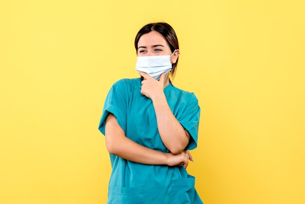 La vista lateral del médico con una máscara está pensando en los síntomas del covid