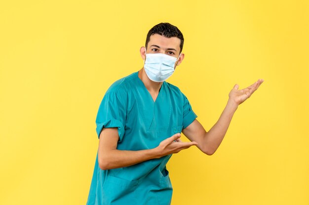 Vista lateral de un médico con máscara un médico habla sobre la importancia de lavarse las manos durante una pandemia