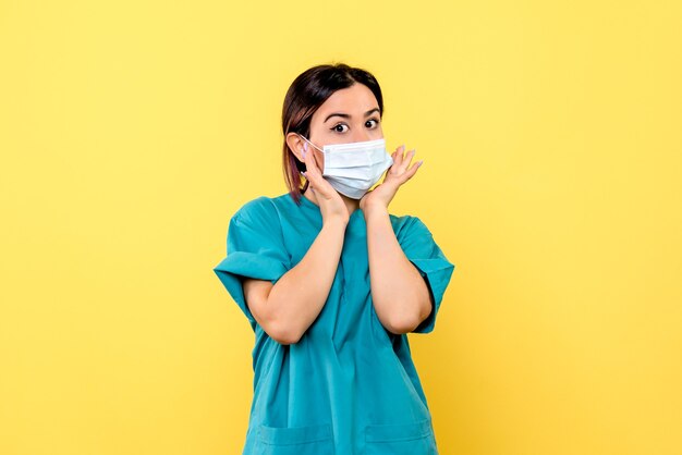 Vista lateral de un médico con máscara, un médico con máscara está hablando de pacientes con covid