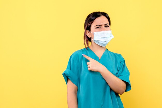 Vista lateral del médico con una máscara que conoce los tratamientos para el covid