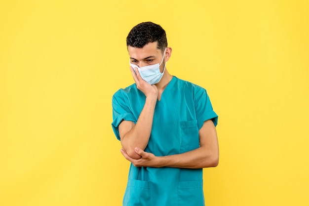Vista lateral de un médico un médico con máscara está pensando en los pacientes con coronavirus