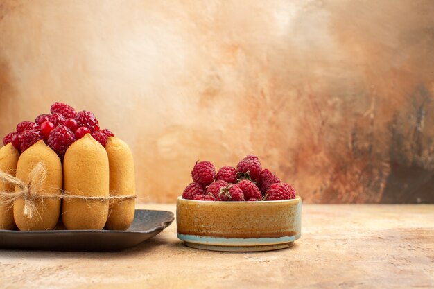 Vista lateral de la mesa con un pastel de regalo y frutas para los invitados en la mesa de colores mezclados