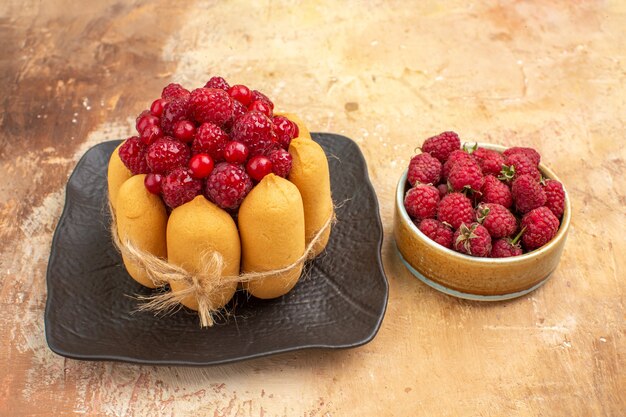 Foto gratuita vista lateral de la mesa con un pastel de regalo y frutas para los invitados en la mesa de colores mezclados