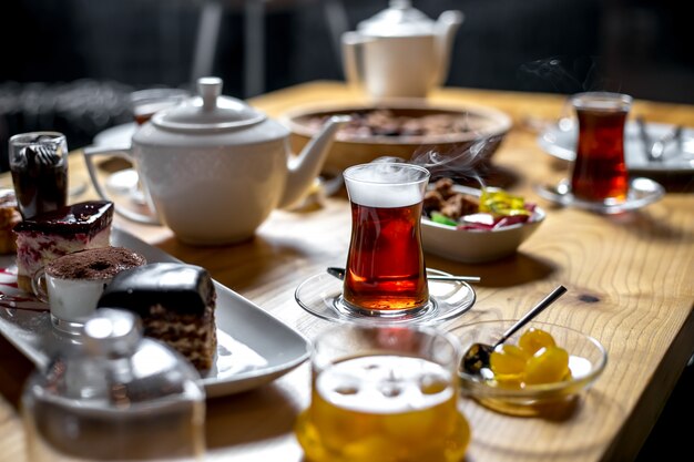 Vista lateral de la mesa de té dulce con un vaso de armudu de té
