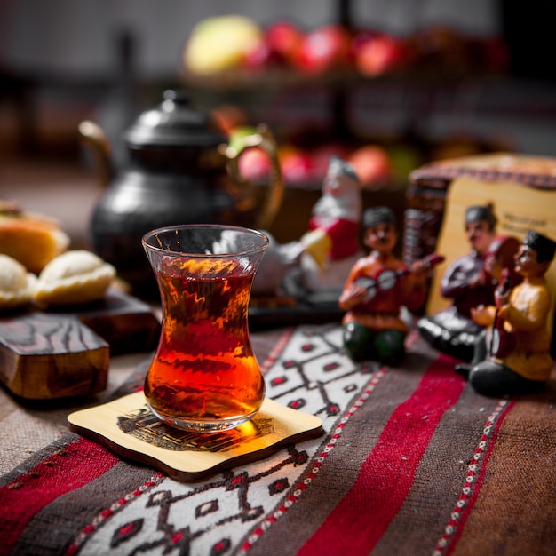 Foto gratuita vista lateral mesa de té con un vaso de té y figuras y tetera en la mesa en el restaurante