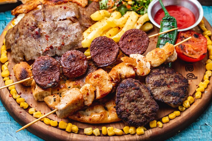 Foto gratuito vista lateral mezclar kebabs chuletas de carne a la parrilla brochetas de pollo y chorizo sucuk pimiento verde picante tomate verde a la parrilla maíz dulce y papas fritas en pan