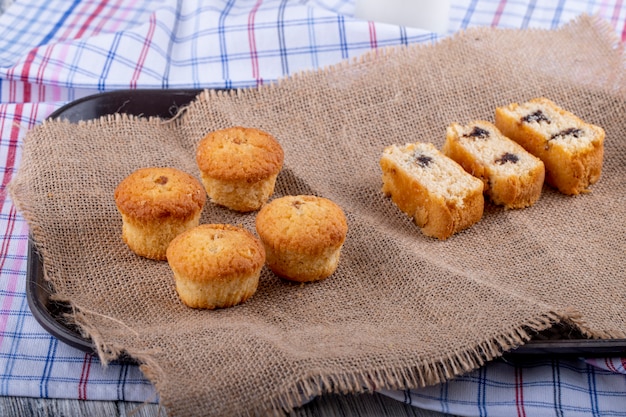 Vista lateral de muffins y bizcochos sobre tela de saco