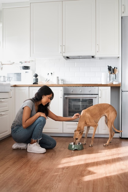 Foto gratuita vista lateral mujer alimentando perro