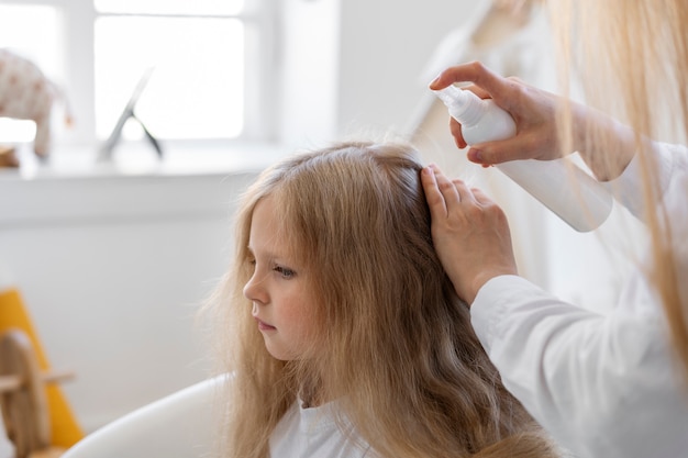 Foto gratuita vista lateral mujer ayudando a niña con piojos