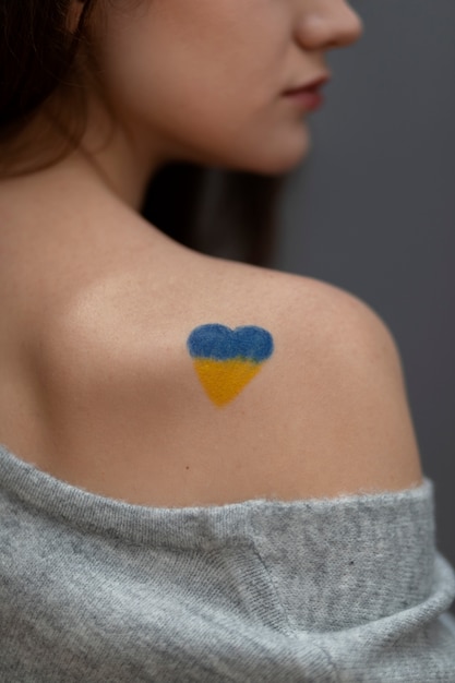 Foto gratuita vista lateral mujer con bandera ucraniana pintada