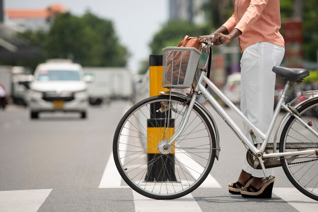 Vista lateral mujer con bicicleta en la calle