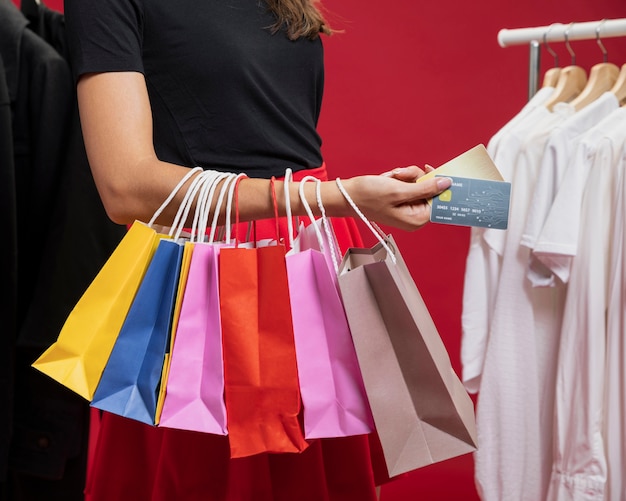 Vista lateral mujer con bolsos coloridos en compras