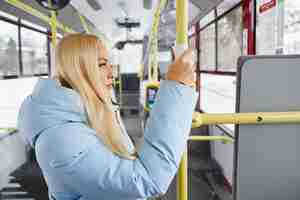 Foto gratuita vista lateral de una mujer bonita con chaqueta azul sosteniendo el pasamanos a través de una servilleta de pie en movimiento