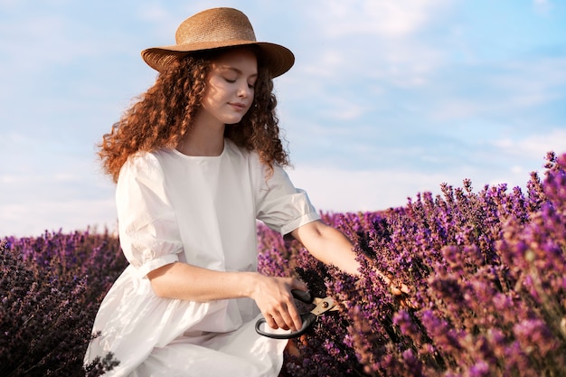 Foto gratuita vista lateral mujer en campo de lavanda