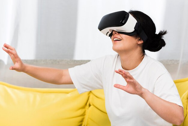 Vista lateral de la mujer en casa con casco de realidad virtual