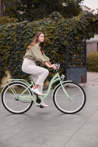 Vista lateral de la mujer en la ciudad en bicicleta