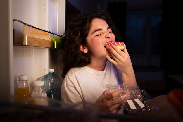 Vista lateral mujer comiendo donut