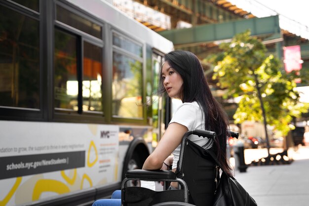 Vista lateral mujer discapacitada esperando el autobús