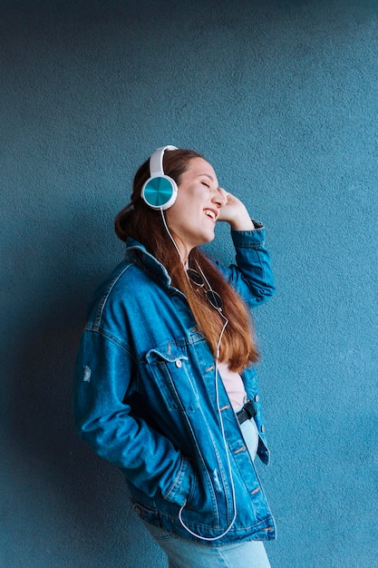 Foto gratuita vista lateral de la mujer disfrutando de escuchar música con auriculares