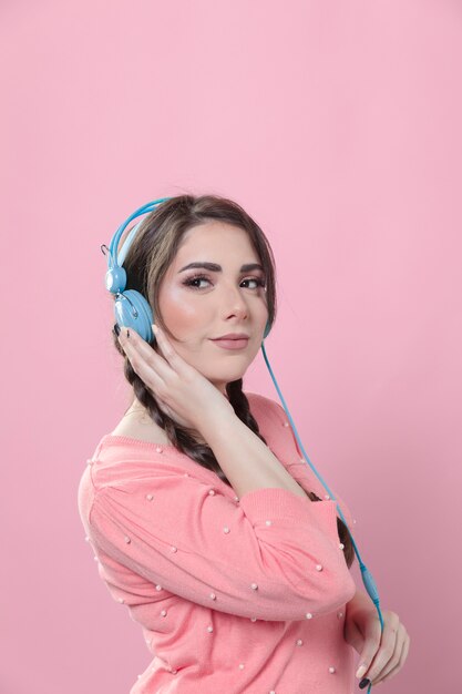 Vista lateral de la mujer disfrutando de la música en los auriculares con espacio de copia