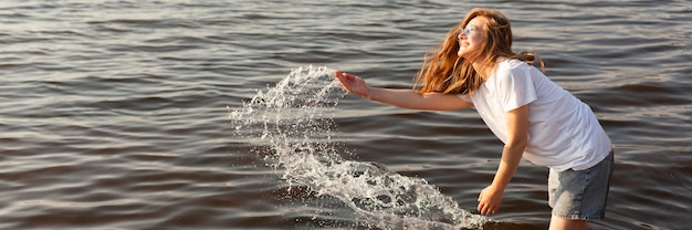 Vista lateral de la mujer divirtiéndose en el agua con espacio de copia