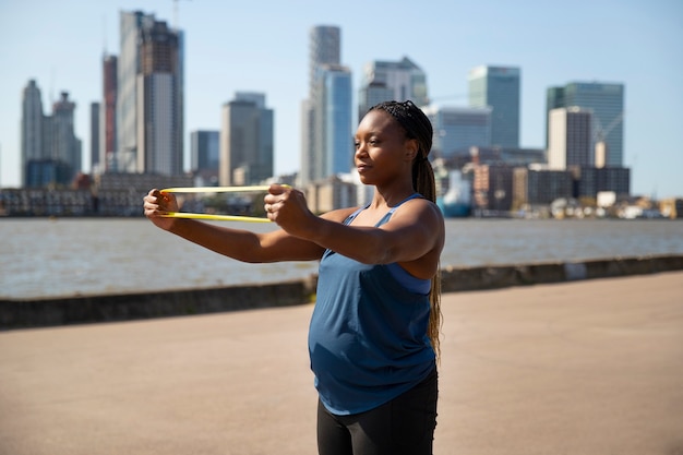 Vista lateral mujer embarazada haciendo deporte al aire libre