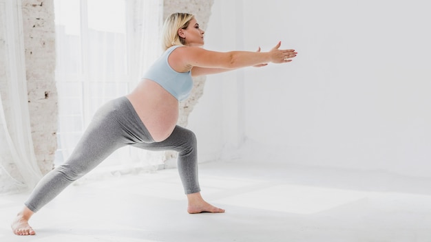 Vista lateral mujer embarazada haciendo ejercicios