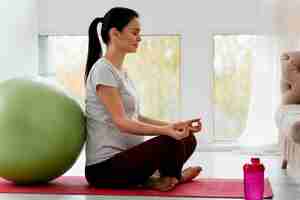 Foto gratuita vista lateral de la mujer embarazada meditando con espacio de copia