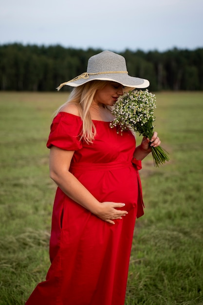 Vista lateral mujer embarazada pasando tiempo al aire libre