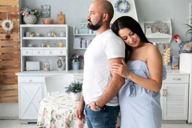 Vista lateral mujer embarazada sosteniendo el brazo de su marido